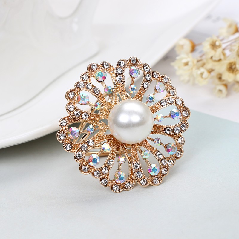 Elegantná zlatá brošňa s bielou perlou a kryštálikmi s prepracovaným dizajnom
